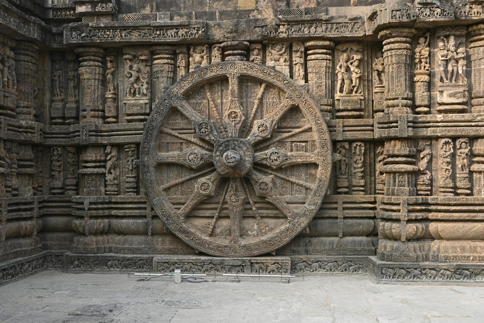 Detailed view of a carved stone wheel at Konark Sun Temple, showcasing ancient Indian art.